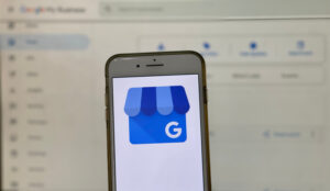 Google Business Profile icon on a smartphone screen, the Insights page out of focus in the background